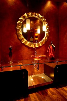 Un gran espejo refleja la luz creando la ilusión de espacio en un baño pequeño